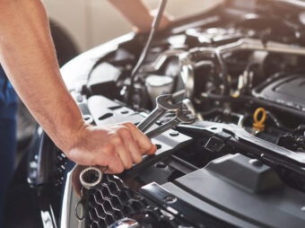 Picture showing muscular car service worker repairing vehicle