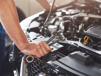 Picture showing muscular car service worker repairing vehicle