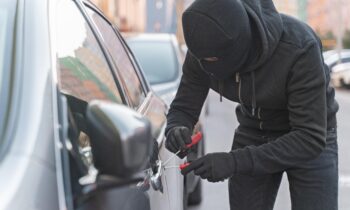 nahaufnahme-eines-mannes-der-versucht-ein-auto-einzubrechen